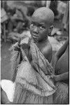 Mortuary ceremony, Omarakana: mourning girl with fiber shawl, turtle shell earrings, her face blackened with ash and head shaved