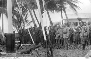 Troops cheering the unfurling of the British flag at the German Government Station on the surrender of Nauru.  In the foreground (left) is Captain Norrie Officer Commanding (OC) (later Colonel of ..