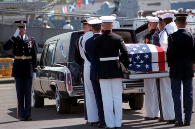 A joint services casket team takes the casket of the Unknown Serviceman of the Vietnam Era from a hearse, to be aboard the frigate USS BREWTON (FF 1086). The casket will be transported by ship to Alameda, California, and then transferred to Arlington National Cemetery for interment at the Tomb of the Unknowns