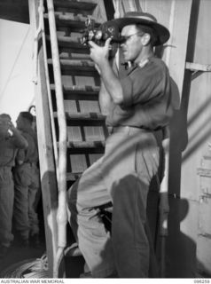 BLANCHE BAY, RABAUL, NEW BRITAIN. 1945-09-10. LIEUTENANT F.S. WOOD, MILITARY HISTORY SECTION, ABOARD HMAS MANOORA FILMING THE ENTRY INTO SIMPSON HARBOUR. THE MANOORA CARRIED TROOPS FOR THE ..