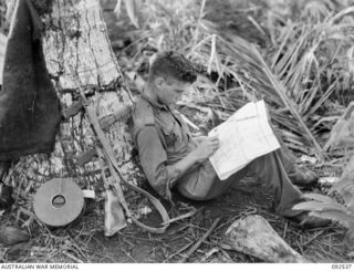 BOUGAINVILLE. 1945-05-24. PRIVATE J.B. CRACE, I SECTION, 26 INFANTRY BATTALION (AUSTRALIAN IMPERIAL FORCE), CHECKS LATEST ENEMY POSITIONS ON THE MAPS PRIOR TO SETTING OUT ON PATROL AGAINST THE ..
