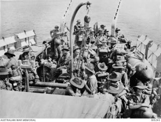 1942-12-13. TROOPS FROM THE 2/9TH BATTALION AIF ON THE QUARTERDECK OF THE CORVETTE HMAS BROOME, EN ROUTE FROM MILNE BAY TO THE BUNA AREA. NOTE THE KITE/OTTERS AND FLOATS OF THE OROPESA MINESWEEPING ..