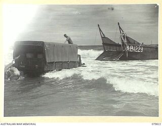 TOKO, BOUGAINVILLE, SOLOMON ISLAND. 1945-03-21. A 3 TON TRUCK OF THE 7TH INFANTRY BRIGADE LOADED WITH SUPPLIES, BACKS FROM AN AUSTRALIAN LANDING CRAFT DURING LANDING OPERATIONS