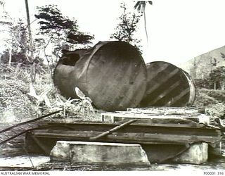 NEW BRITAIN, 1945-09. DAMAGED STORAGE TANKS NEAR RABAUL. (RNZAF OFFICIAL PHOTOGRAPH.)