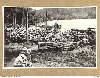 FINSCHHAFEN, NEW GUINEA. 1943-11-20. A TRACTOR HAULING A 25 POUNDER GUN AWAY FROM THE BEACHHEAD