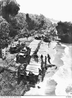 1943-09-28. LAE SALAMAUA. ISOLATED. ONE OF THE BEACHES NORTH WEST OF LAE WHERE AUSTRALIAN TROOPS HAD MADE THEIR HAPPIEST LANDING OF THE NEW GUINEA WAR. HARD UP AGAINST THE BEACH IS A LANDING CRAFT ..