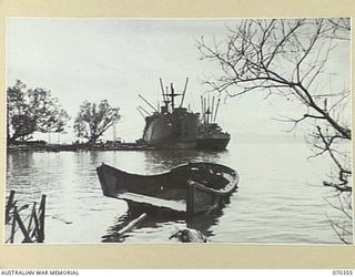 MILNE BAY, NEW GUINEA, 1944-02-10. THE DERELICT JAPANESE BARGE IN THE FOREGROUND STANDS AS A SILENT REMINDER OF AN UNSUCCESSFUL JAPANESE ATTACK ON MILNE BAY ON 1942-08-09. IT IS PROBABLY ONE OF ..