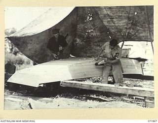 LAE, NEW GUINEA. 1944-03-30. NX57470 PRIVATE K. BRADLEY (LEFT), WITH QX24263 SERGEANT S. C. WOODFORTH (RIGHT), MEMBERS OF THE 2ND MARINE FOOD SUPPLY PLATOON MAKING SKIFFS 16 FEET IN LENGTH. THE ..