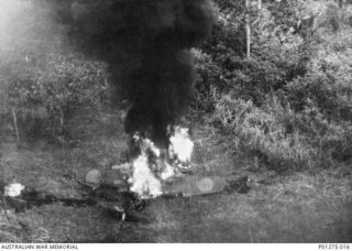 Lae, New Guinea. 1943-03-04. Black smoke and flames rise from a Japanese Zero fighter aircraft and a petrol tanker on fire after attack by Beaufighter aircraft of No. 30 Squadron RAAF. Allied ..