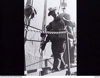 SYDNEY, NSW. 1946-05-09. QX6221 PRIVATE E. STEPHENSON, ONE OF 1550 AMF PERSONNEL, COMING DOWN THE GANGPLANK OF TROOPSHIP DUNTROON AFTER HER ARRIVAL AT CIRCULAR QUAY FROM KURE, MOROTAI AND RABAUL