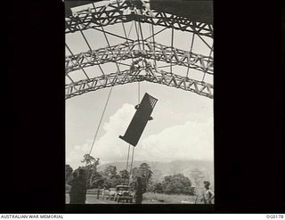 VIVIGANI, GOODENOUGH ISLAND, PAPUA NEW GUINEA. 1943-09-23. ROOFING IRON BEING LIFTED BY MEMBERS OF NO. 7 MOBILE WORKS SQUADRON RAAF DURING THE CONSTRUCTION OF AN "IGLOO" HANGAR