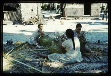 Mary, Teinano, and Alice Marsters weaving green coconut baskets, Palmerston Island