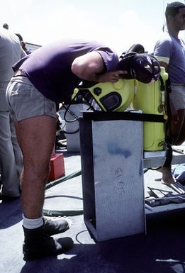 A member of Mobile Diving Salvage Unit 1 checks his gear before diving at the USS ARIZONA Memorial site. Salvage Unit 1 is participating in the joint Navy/Park Service project SeaMark, a surveying and charting effort to assess submerged cultural resources in the Pacific