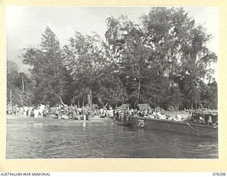 SIPAAI, BOUGAINVILLE ISLAND. 1945-01-07. TROOPS OF THE 31/51ST INFANTRY BATTALION UNLOADING THE UNIT STORES FROM BARGES OF THE 42ND LANDING CRAFT COMPANY AT THE UNIT BEACH-HEAD AT THE MOUTH OF THE ..