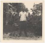 Man holding kundu drums and sing sing head dress, Panapai Plantation, New Ireland, Jan 1940