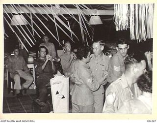 LAE AREA, NEW GUINEA. 1945-07-24. A SECTION OF THE 2/1 GUARD REGIMENT BAND PLAYING DURING A DANCE HELD BY THE STAFF OF THE AUSTRALIAN ARMY CANTEEN SERVICES