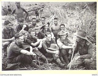 KIARIVU, NEW GUINEA, 1945-08-06. CHAPLAIN O'KEEFE (1), TALKING WITH TROOPS OF 2/7 INFANTRY BATTALION AFTER ARRIVAL AT AN INTERMEDIATE OBJECTIVE DURING THEIR SIX DAY PATROL INTO ENEMY TERRITORY