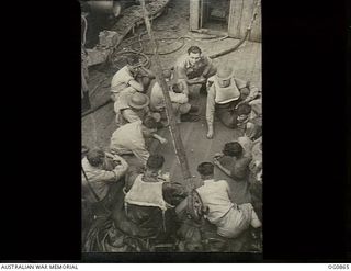 AT SEA BETWEEN GOODENOUGH ISLAND AND THE TROBRIAND ISLANDS, PAPUA. 1943-11-27. AIRMEN OF NOS. 22 AND 30 SQUADRONS RAAF STARTED A GAME OF DICE ON DECK TO PASS AWAY THE TIME ABOARD THE SS HANYANG ..