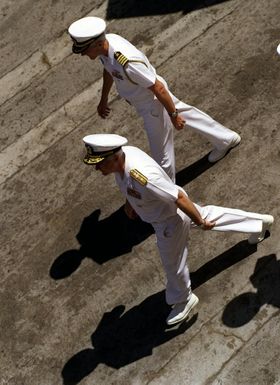 RDML Timothy J. Keating, Commander, Carrier Group Five, with an unidentified Navy captain walks from the aircraft carrier USS INDEPENDENCE (CV 62) to board the carrier USS KITTY HAWK (CV 63) passing the pennant of Battle Force Seventh Fleet, Surface Combatant Force Seventh Fleet, Carrier Strike Force Seventh Fleet, Carrier Group Five from one ship to the other