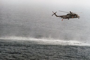 A right side view of a Helicopter Mine Countermeasures Squadron 14 (HM-14) RH-53D Sea Stallion helicopter towing a lightweight magnetic sweep during mine contermeasures operations. The helicopter is assigned to the amphibious assault ship USS GUAM (LPH 9). Note: First view in a series of six