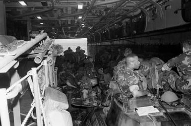 Marines of the 2nd Light Armored Infantry Battalion, 4th Marine Regiment, sit on their vehicles aboard a utility landing craft (LCU) in the well deck of the amphibious assault ship USS SAIPAN (LHA-2) during Fleet Ex 1-90