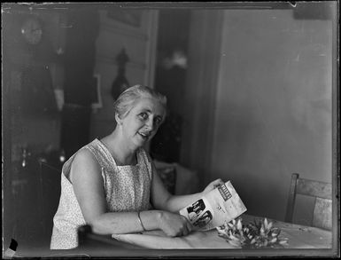 Mrs Barron, reading a Whites Aviation magazine [probably in her home?], Rarotonga, Cook Islands