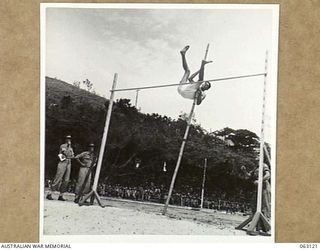 ELA BEACH, NEW GUINEA. 1944-01-01. QX37561 PRIVATE J. B. GORMAN OF THE 2/12TH INFANTRY BATTALION, CLEARING 9' 6" TO WIN THE POLE VAULT EVENT AT THE ALLIED SERVICES GRAND SPORTS CARNIVAL