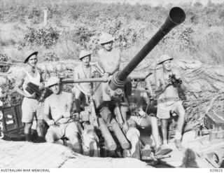PORT MORESBY, 1942-07. FOLLOWING AN ALARM THAT JAPANESE PLANES WERE IN THE VICINITY, THIS AUSTRALIAN ANTI-AIRCRAFT CREW IN NEW GUINEA WAS PHOTOGRAPHED JUST AFTER REACHING ACTION STATIONS AND WHILE ..