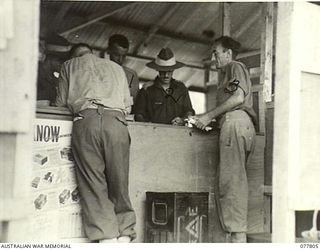 LAE BASE AREA, NEW GUINEA. 1944-12-27. THE ORDERLY ROOM OF THE 13TH WORKSHOPS AND PARK COMPANY. IDENTIFIED PERSONNEL ARE:- NX143062 SERGEANT E. WALTON (1); NX115504 CAPTAIN H.C. FOSTER (2)