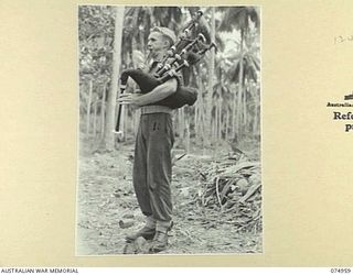 HANSA BAY, NEW GUINEA. 1944-07-29. NX124584 CORPORAL R.V. BRAYLEY, 30TH INFANTRY BATTALION PRACTICING HIS BAGPIPES IN A QUIET SECTION OF THE POTSDAM PLANTATION