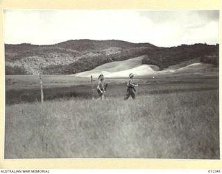 MYOLA NO.1, NEW GUINEA. 1944-04-07. QX267390 SIGNALMAN B. BAKER (1), AND N442544 SIGNALMAN W.R. DAVIES (2), MEMBERS OF THE 23RD LINE SECTION, 18TH LINES OF COMMUNICATION SIGNALS RETURNING FROM A ..