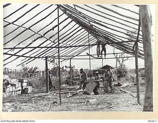 CAPE WOM, NEW GUINEA. 1945-05-29. TROOPS AT WORK ON A BUILDING TO HOUSE ORDNANCE STORES AT THE FIELD MAINTENANCE CENTRE