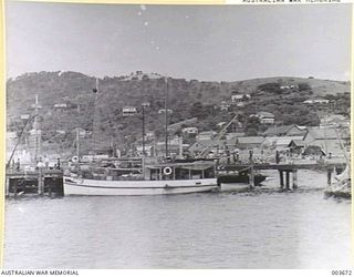 A small coastal trading vessel tied up at a jetty in Fairfax Harbour