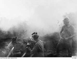 1943-07-31. ALLIED CAPTURE OF MUBO. AMERICAN ARTILLERY SHELLING JAPANESE POSITIONS NEAR MUBO. THE GUNS HAD TO BE MANHANDLED BY NATIVES AND ALLIED SOLDIERS OVER VERY ROUGH JUNGLE COUNTRY. (NEGATIVE ..