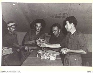 NAMANULA, NEW BRITAIN. 1945-10-10. AN AUSTRALIAN COMFORTS FUND ISSUE OF 4-OZS OF TOBACCO BEING ISSUED TO TROOPS THROUGH THE UNIT CANTEEN AT HEADQUARTERS 11 DIVISION