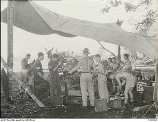 THE SERVICING PARTY OF NO. 24 (VENGEANCE) SQUADRON RAAF AT WORK BESIDE THE AIRSTRIP UNDER A MAKESHIFT TENT