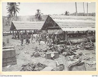 MUSCHU ISLAND, NEW GUINEA. 1945-10-10. MAJOR E.S. OWENS, ASSISTANT ADJUTANT AND QUARTERMASTER GENERAL, HEADQUARTERS 6 DIVISION, MAKING AN INSPECTION OF JAPANESE BARRACKS, SIMPLY CONSTRUCTED FROM ..