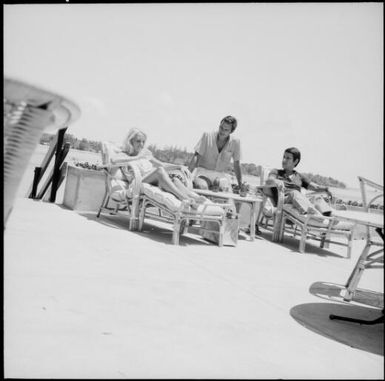 Three tourists having a drink on the verandah of Le Lagon Resort, New Hebrides, November 1969 / Michael Terry