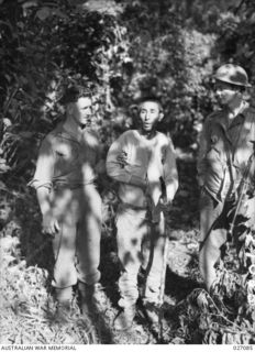 PAPUA, NEW GUINEA. 1942-10. TWO SOLDIERS OF THE A.I.F. SUPPORTING A JAPANESE PRISONER CAPTURED BY THE 3RD AUSTRALIAN INFANTRY BATTALION (C.M.F.) NEAR MENARI. HE WAS VERY WEAK AND EMACIATED