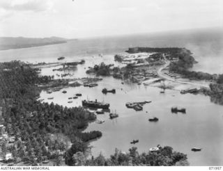 FINSCHHAFEN, NEW GUINEA. 1944-04-03. AN AERIAL VIEW TOWARDS THE OCEAN SHOWING SHIPPING AND PORT INSTALLATIONS AT THE HARBOUR