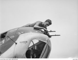 TADJI NEAR AITAPE, NORTH EAST NEW GUINEA. C. 1944-10. 8 405607 LEADING AIRCRAFTMAN D. E. STEER, SYDNEY, NSW, WORKING ON .303 GUNS IN THE FRONT TURRET OF A BEAUFORT BOMBER AIRCRAFT OF NO. 8 SQUADRON ..