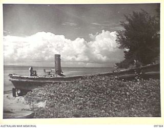 BUIN AREA, BOUGAINVILLE. 1945-09-28. A JAPANESE BARGE, NOW OVERGROWN WITH WEEDS, WHICH RAN ASHORE AT KANGU HILL, A JAPANESE ANTI-AIRCRAFT STRONGPOST, AFTER ALLIED BOMBING NEAR BUIN NAVAL ..