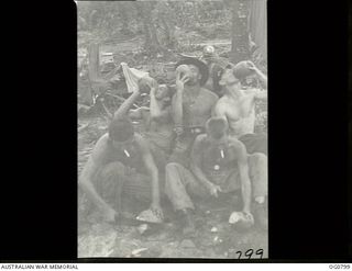 LOS NEGROS ISLAND, ADMIRALTY ISLANDS. 1944-03-18. RAAF AIRMEN OPENING COCONUTS AND DRINKING THE MILK. SHOWN: LEADING AIRCRAFTMAN (LAC) F. HINES, GRANVILLE, NSW; LAC I. CUMES, SHERWOOD, QLD; LAC R. ..