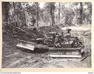 BOUGAINVILLE, 1945-07-16. A BULLDOZER OF 6 MECHANICAL EQUIPMENT COMPANY, ATTACHED 3 DIVISION, CLEARING AWAY THE TOP SOIL DURING THE CONSTRUCTION OF A NEW 3-TONNER ROAD BETWEEN THE MOBIAI AND THE ..