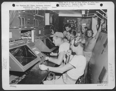 When Bad Weather Cuts Visibility To A Minimum, 'Zippo', A High Precision Radar Device, Insures A Safe Landing To Incoming Aircraft At Harmon Field, Guam Air Depot, Guam, Marianas Islands. Operators At The Cathode-Ray Screens And Controls Contact The Plan (U.S. Air Force Number 60294AC)