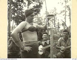 GUSIKA, NEW GUINEA, 1944-03-17. VX14416 SIGNALMAN J. FRENCH (1), OF "TRENKNERS TROUBADOUR BAND", FORMED BY MEMBERS OF THE 29/46TH INFANTRY BATTALION, 4TH INFANTRY BRIGADE, USING INSTRUMENTS ..