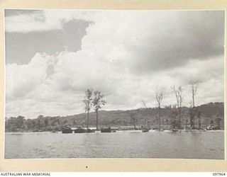 WEWAK BEACH, NEW GUINEA. 1945-10-18. BARGES LINING THE BEACH WAITING TO BE UNLOADED BY PERSONNEL OF 8 PORT OPERATING COMPANY
