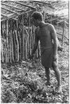 Man holding leaf in ritual, reciting spell