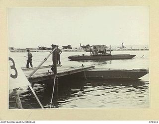 BOUGAINVILLE ISLAND, 1945-01-19. A PONTOON FERRY TRANSPORTING AN AUSTRALIAN ARMY JEEP ACROSS THE JABA RIVER