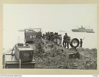 JACQUINOT BAY, NEW BRITAIN. 1944-11-05. A NATIVE WORKING PARTY BOARDING AN LCM (LANDING CRAFT MECHANISED) AT THE MALMAL MISSION BEACH DURING THE LANDING OF THE 6TH INFANTRY BRIGADE